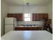 Bright kitchen features white appliances, wood cabinets, double sink, and a center island for extra counter space at 1131 S Pershing Ave, Indianapolis, IN 46221