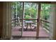 View of the back deck through sliding glass doors showcasing outdoor seating and a wooded backdrop at 11506 Hidden Bay, Indianapolis, IN 46236