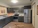 Kitchen featuring stainless steel appliances, marbled countertops, and dark cabinets on wood-look floors at 11506 Hidden Bay, Indianapolis, IN 46236