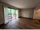 Living room features wood-look floors and sliding glass doors leading to an outdoor deck and greenery at 11506 Hidden Bay, Indianapolis, IN 46236