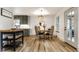Bright dining area with a wood table, woven light fixture, and updated flooring, conveniently located near the kitchen at 1240 E 56Th St, Indianapolis, IN 46220