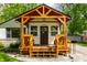Inviting covered front porch featuring a stained wood porch, decorative door, and stone landscaping at 1240 E 56Th St, Indianapolis, IN 46220