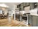 Open-concept kitchen and dining area with stainless steel appliances, gray cabinetry, and stylish decor at 1240 E 56Th St, Indianapolis, IN 46220