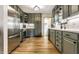 Modern kitchen with stainless steel appliances, gray cabinets, herringbone backsplash, and wood floors at 1240 E 56Th St, Indianapolis, IN 46220