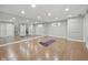 Large, well-lit basement room with mirrored wall and wood laminate flooring at 13094 Overview Dr # 5D, Fishers, IN 46037