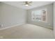 Bright, neutral bedroom features a ceiling fan and large window with neighborhood views at 13094 Overview Dr # 5D, Fishers, IN 46037