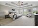 Serene main bedroom featuring a tray ceiling, carpeted floor, and large windows for natural light at 13094 Overview Dr # 5D, Fishers, IN 46037