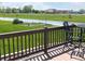 Exterior shot of a wood deck with patio furniture overlooking a green lawn, garden and pond at 14058 Southwood Cir, Fishers, IN 46037