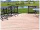 Exterior shot of a wood deck with patio furniture overlooking a green lawn and pond at 14058 Southwood Cir, Fishers, IN 46037