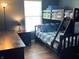 Cozy bedroom boasts a wooden bunk bed with plaid bedding, a dresser and hardwood floors at 14058 Southwood Cir, Fishers, IN 46037