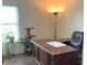Well-lit home office features a hardwood floor, large wooden desk, and an ergonomic office chair at 14058 Southwood Cir, Fishers, IN 46037