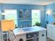 Bright home office painted in blue with white trim boasts ample natural light, island worktop and nautical decorations at 14058 Southwood Cir, Fishers, IN 46037