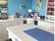 Bright home office painted in blue with built in storage cabinets, desk, and personal decorations at 14058 Southwood Cir, Fishers, IN 46037