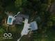 Aerial view showcasing the home, pool, outbuildings, and wooded surroundings at 1490 N County Road 50 E, Danville, IN 46122