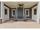 Relaxing covered porch with ceiling fan, seating, and access doors at 1490 N County Road 50 E, Danville, IN 46122