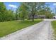 Spacious front yard showcasing lush greenery, a charming playhouse, and a gravel driveway at 1490 N County Road 50 E, Danville, IN 46122