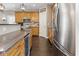 Well-lit kitchen boasting wood cabinets, granite countertops, stainless steel appliances and hardwood floors at 1490 N County Road 50 E, Danville, IN 46122