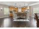 Bright kitchen features hardwood floors, stainless appliances, wood cabinets, and an eat-in bar area with stylish seating at 1490 N County Road 50 E, Danville, IN 46122