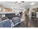 Open-concept living room showcases a modern gray sofa, dark wood floors and seamless flow to the dining and kitchen areas at 1490 N County Road 50 E, Danville, IN 46122