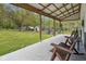 Covered porch with outdoor seating overlooking the large, fenced-in backyard with animal shelters at 1490 N County Road 50 E, Danville, IN 46122
