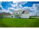 Expansive backyard featuring a covered patio, lush green lawn, and a freshly painted white home exterior at 15792 Wiseman Dr, Fishers, IN 46040