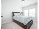 Calm bedroom with a dark wooden bed frame and blue accents, featuring large windows and neutral carpet at 15792 Wiseman Dr, Fishers, IN 46040