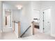 Well-lit upstairs hallway with carpet flooring, wooden banister, and doorway view of a bedroom at 15792 Wiseman Dr, Fishers, IN 46040