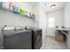 Well-organized laundry room with modern washer and dryer, shelving for supplies, and convenient folding counter at 15792 Wiseman Dr, Fishers, IN 46040