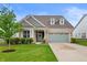 Charming home featuring brick and siding, a well-manicured lawn, and a sage green two-car garage at 16270 Northwind Ct, Westfield, IN 46074
