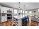 Bright, updated kitchen with stainless steel appliances, white cabinets, an island with seating, and hardwood floors at 16270 Northwind Ct, Westfield, IN 46074