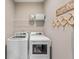 Practical laundry room with modern white washer and dryer, wire shelving and decorative laundry sign at 16270 Northwind Ct, Westfield, IN 46074