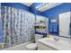 This bathroom features vibrant blue walls and a tub with a stylish blue and white floral shower curtain at 1663 Sweetgum Dr, Greenwood, IN 46143