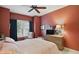 Bedroom featuring red walls, ceiling fan, bed, and a sitting chair at 1663 Sweetgum Dr, Greenwood, IN 46143