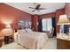 Bedroom featuring red walls, ceiling fan, bed, and a sitting chair at 1663 Sweetgum Dr, Greenwood, IN 46143