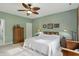 Bedroom features include pale green walls, carpeted floors, a ceiling fan, and a window that allows in natural light at 1663 Sweetgum Dr, Greenwood, IN 46143