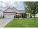 Charming brick and siding home features a well-manicured lawn and a two-car garage at 1663 Sweetgum Dr, Greenwood, IN 46143