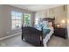 Cozy bedroom with natural light from two large windows, and a dark wooden bed frame at 1783 Trillium Ct, Avon, IN 46123