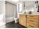 Bathroom featuring a modern vanity with a marble countertop, stylish mirror, and tub with shower at 2036 Central Ave, Indianapolis, IN 46202
