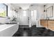 Modern bathroom featuring freestanding tub, frameless glass shower, and floating vanity with black marble floors at 2036 Central Ave, Indianapolis, IN 46202