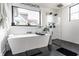 Bathroom featuring a freestanding tub next to a frameless glass shower and a large window at 2036 Central Ave, Indianapolis, IN 46202