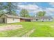 A spacious backyard featuring lush green grass and a neutral-toned house under a blue sky with clouds at 212 W Banta Rd, Indianapolis, IN 46217