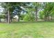 Large, grassy backyard featuring mature trees, providing ample space for outdoor activities and shaded relaxation at 212 W Banta Rd, Indianapolis, IN 46217