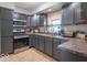 Well-lit kitchen features stainless steel appliances, gray cabinets, and tile flooring at 212 W Banta Rd, Indianapolis, IN 46217