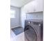 Laundry room showcasing a large washing machine and white cabinetry at 212 W Banta Rd, Indianapolis, IN 46217