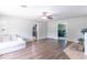 Bright living room with hardwood floors, a fan, neutral walls, and a view into the kitchen and office at 212 W Banta Rd, Indianapolis, IN 46217
