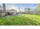 Expansive backyard with a mix of grass and dandelions, featuring an old detached garage at 2221 Station St, Indianapolis, IN 46218