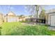 Spacious backyard with greenery, includes a detached structure and partial fencing at 2221 Station St, Indianapolis, IN 46218