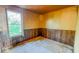 Small bedroom with wood paneled walls, a window, and worn carpeting throughout at 2221 Station St, Indianapolis, IN 46218
