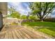 Spacious backyard featuring a wooden deck with chairs, well-maintained lawn, and mature trees providing ample shade at 2319 E 40Th St, Anderson, IN 46013