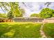 Expansive backyard showing the house, lush green lawn, privacy fence, and a charming stone pathway at 2319 E 40Th St, Anderson, IN 46013